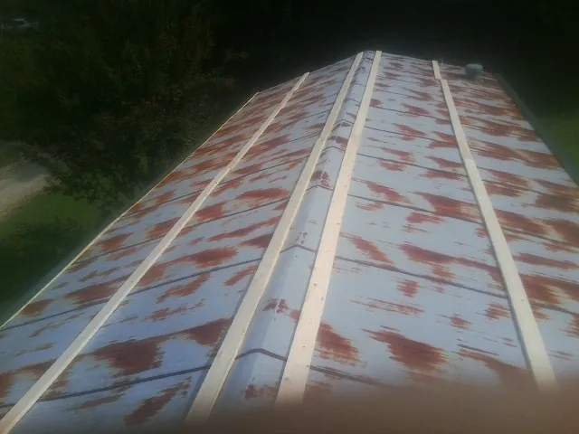 Rusted metal roof panels with new wood purlins before replacement — Storm Damage Roof Repair in Rincon by Roofing Brothers