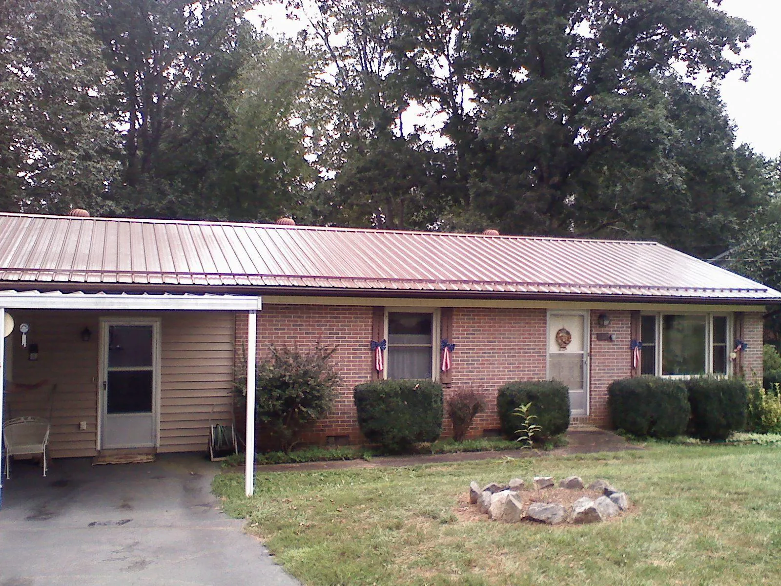 Bronze metal roof and carport on a brick ranch home — Roof Repair work by our crew in Rincon