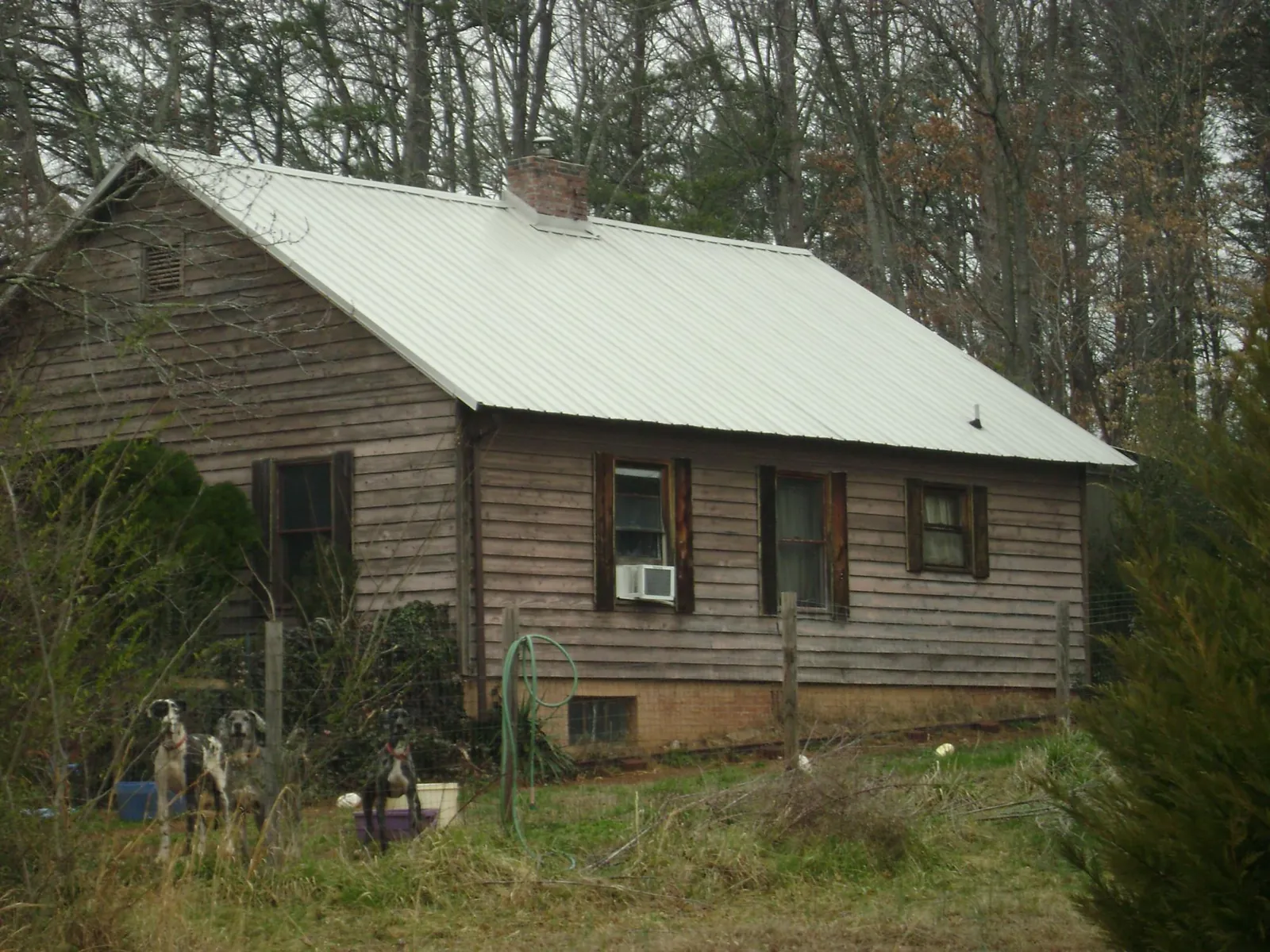 White metal roof on an old wood sided farmhouse, from a Metal Roof Installation job in Rincon